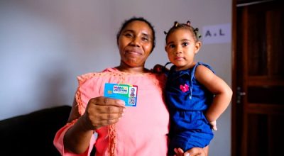 Mulher com crianca no colo mostra cartao do programa Maranhao Livre da Fome